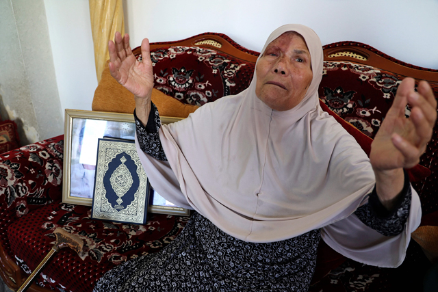   Fathiyeh Al Ardeh, mother of Mahmoud Al Ardeh, one of six Palestinian prisoners who escaped from Israel’s Gilboa Prison, holds up her hands as she prays for him at her home in the village of Arabah, south of Jenin in the occupied West Bank, on Wednesday (AFP photo)