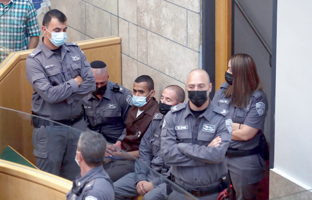 Palestinian Munadel Infeiat, 26, one of the six prisoners who had tunnelled out of Israel's high security Gilboa Prison, is surrounded by Israeli forces as he appears at the magistrates' court in the northern Israeli city of Nazareth on Sunday (AFP photo)