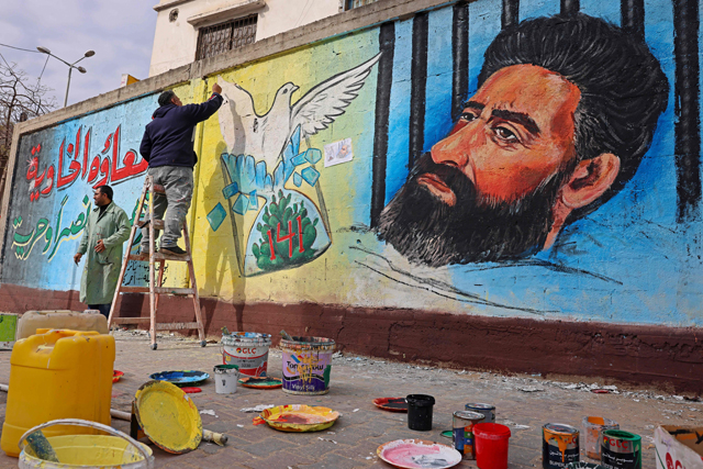 Palestinian artists draw a mural of Hisham Abu Hawash, a Palestinian prisoner who ended his hunger strike after Israel committed to his eventual release, in Gaza City on Wednesday (AFP photo)