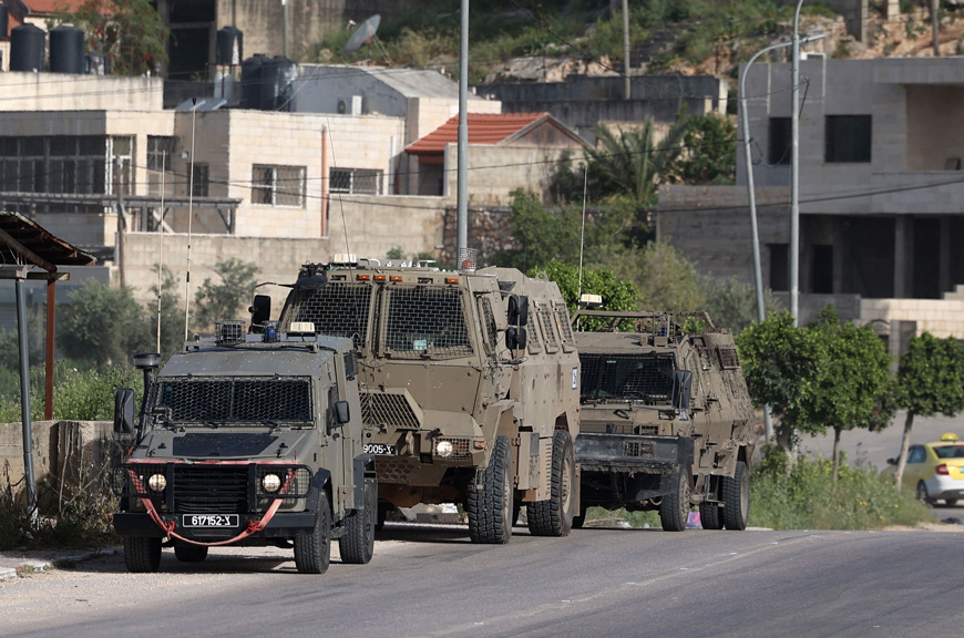 Israeli vehicles are positioned at the entrance of the Nur Shams Palestinian refugee camp near the northern West Bank town of Tulkarem on Sunday (AFP photo)