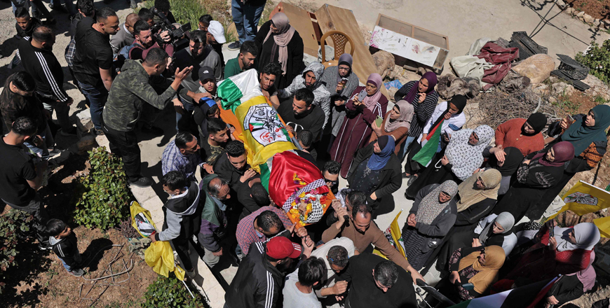 Mourners carry the body of Amer Elyan, draped in the Palestinian flag and the flag of the Fateh movement, during the funeral in Silwad north of Ramallah in the occupied West Bank, on Thursday (AFP photo)