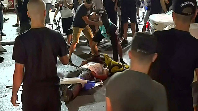This video grab obtained from a footage released by Kan 11 Public broadcaster on Wednesday, shows a far-right Israeli mob attacking who they considered an Arab man, on the seafront promenade of Bat Yam, a town south of Israel's commercial capital Tel Aviv (AFP photo)