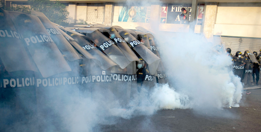 Riot police protect themselves from tear gas thrown back by demonstrators during a protest against the governement of Peru’s President Pedro Castillo, in Lima, on Tuesday (AFP photo)