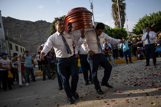 Funeral bearers dance while holding the coffin with the remains of Florentino Jamanca during his funeral in the agricultural town of Humaya in the city of Huacho, about 148 km north of Lima, Peru on May 2 (AFP photo)