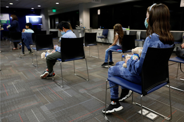 Children wait 15 minutes after receiving their first dose of the Pfizer COVID-19 vaccine at the Beaumont Health offices in Southfield, Michigan, on Friday (AFP photo)