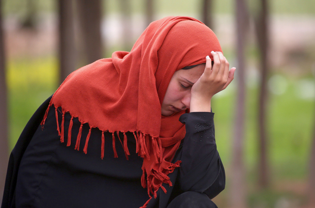 A displaced Syrian woman, who fled Daesh group stronghold of Raqqa, reacts as she arrives at a temporary camp in the village of Ain Issa on Friday (AFP photo)