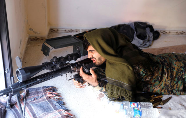 A sniper of Syrian Democratic Forces takes up a position opposite the National Hospital where Daesh militants are holed up at the frontline in Raqqa, Syria, on Monday (Reuters photo)