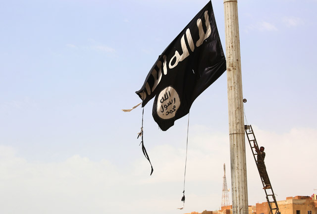 A member of the US-backed Syrian Democratic Forces, made up of an alliance of Arab and Kurdish fighters, removes a Daesh group flag in the town of Tabaqa, about 55 kilometres west of Raqa city, on Sunday, as they advance in their battle for the group’s de facto capital (AFP photo)