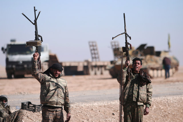 Syrian Democratic Forces fighters hold up their weapons in the north of Raqqa city, Syria, February 3 (Reuters photo)
