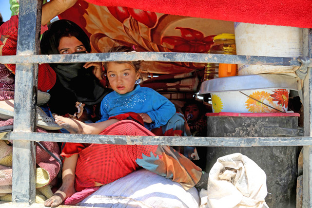 Displaced Syrians who fled the Daesh group stronghold of Raqqa sit in the back of a truck at a temporary camp in the northern Syrian village of Ain Issa on Saturday (AFP photo)