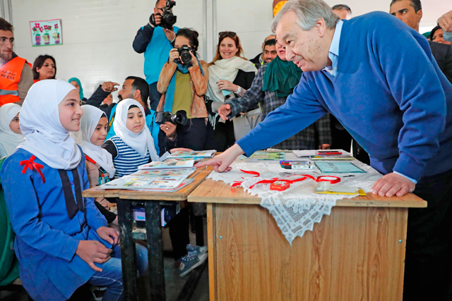 United Nations Secretary General Antonio Guterres (right) talks with Syrian girls during a visit to the Zaatari refugee camp on Tuesday (AFP photo)