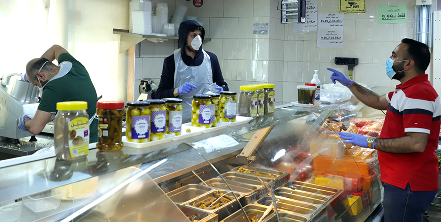 A resident shops at a local store after mini-markets and small grocery stores in residential neighbourhoods opened their doors to the public on Wednesday at 10am (Petra photo)