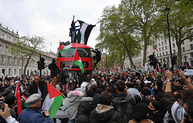 Pro-Palestinian protesters stop a London bus as they participate in a demonstration against Israeli attacks on Palestinians after at least 28 people were killed following clashes over the flashpoint Al Aqsa Mosque in Jerusalem, in central London, on Tuesday (AFP photo)