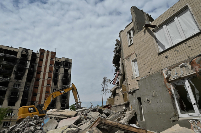 Workers dismantle a heavily damaged residential building in Irpin, on Thursday, amid the Russian invasion of Ukraine (AFP photo)