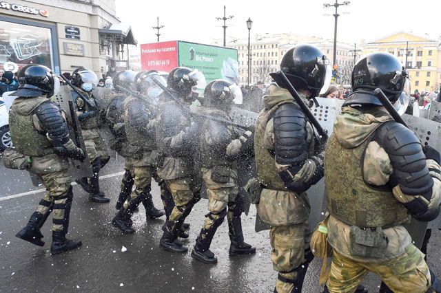 Law enforcement officers are hit by snowballs during a rally in support of jailed opposition leader Alexei Navalny in Saint Petersburg on Sunday (AFP photo)