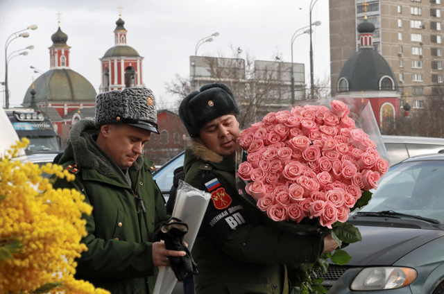 A Russian military police officer holds a bunch of roses near a flower market ahead of International Women’s Day in Moscow, Russia, on Wednesday (Reuters photo)