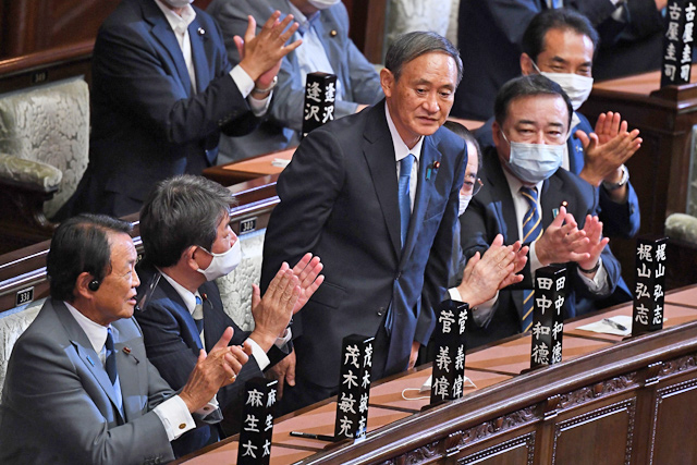 Newly-elected leader of Japan's Liberal Democratic Party Yoshihide Suga (centre) is applauded after he was elected as Japan's prime minister by the Lower House of parliament in Tokyo on Wednesday (AFP photo)