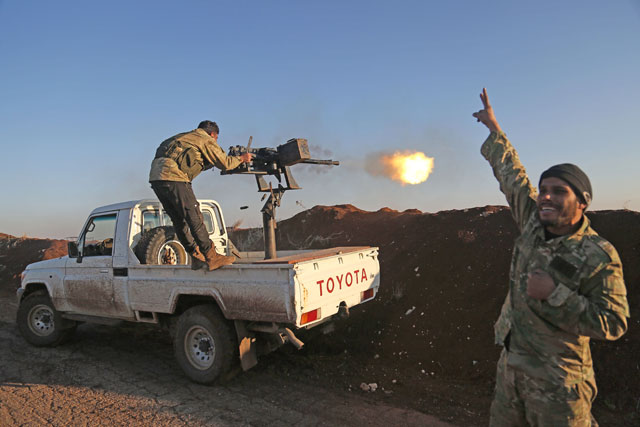 Turkish-backed fighters from the Free Syrian Army stand in the Tal Malid area, north of Aleppo, as they fire towards Kurdish People’s Protection Units positions in the village of Um Al Hosh, in the area of Afrin, on Saturday (AFP photo)