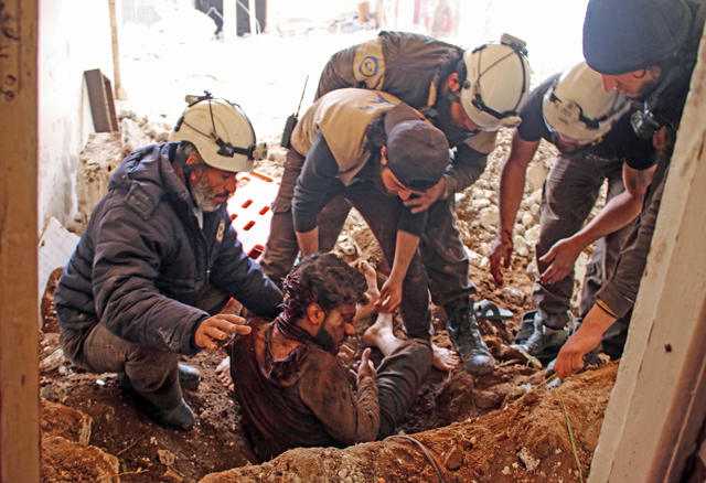 Members of the Syrian civil defence volunteers, also known as the White Helmets, remove a victim from the rubble of his house on Saturday, following a reported air strike by government forces on a rebel-held area in the southern Syrian city of Daraa (AFP photo)