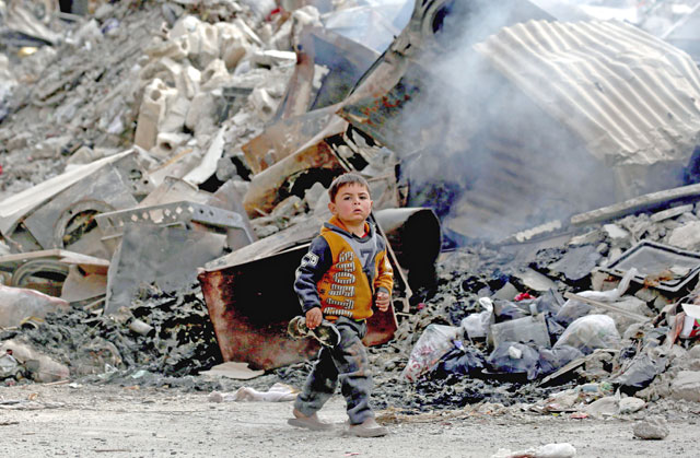 A Syrian child walks past the debris of destroyed buildings in the northern Syrian city of Raqqa, on January 11 (AFP photo)