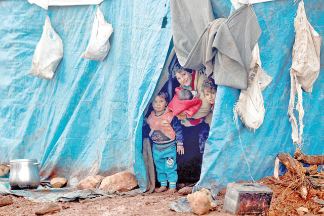 Displaced Syrian children look out from their tents at Kelbit refugee camp, near the Syrian-Turkish border, in Idlib province, Syria, on Wednesday (Reuters photo)