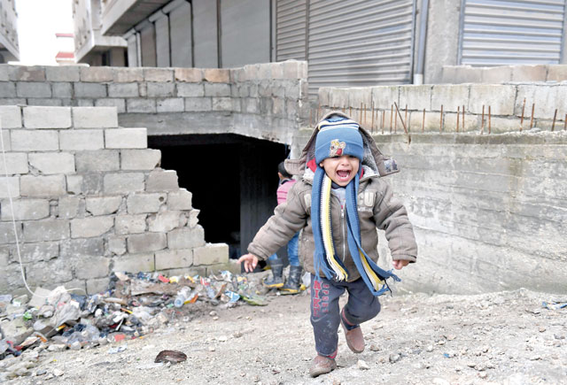 A displaced Syrian child whose family fled from the town of Jandairis in the southwestern corner of the Afrin enclave, where Turkey and allied rebels have been conducting an offensive to oust Kurdish militias, walks in the city of Afrin on Thursday (AFP photo)
