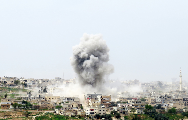 Smoke rises after Syrian regime warplanes reportedly bombed the Menshiyye neighbourhood as Syrian military opposition advances towards the centre of Daraa, Syria, on Monday (Anadolu Agency photo)