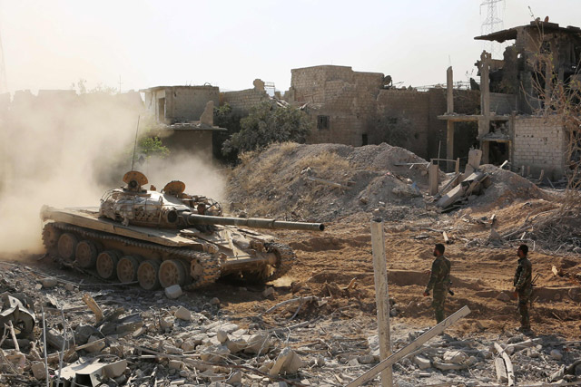 Syrian pro-government forces manoeuvre a tank as they advance through Qabun district, on the outskirts of the capital Damascus, on Saturday, during an offensive to retake the area from opposition fighters (AFP photo)