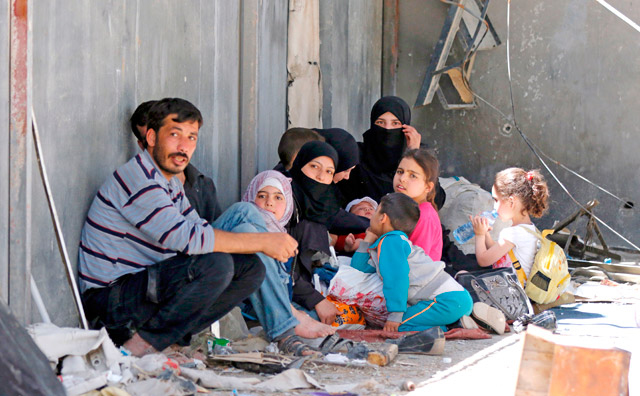 Residents of Al Qaboun, a formerly rebel-held northeastern suburb of Damascus, wait in an area designated by the Syrian government for their cases to be processed after the suburb was retaken by regime forces, on Tuesday, during a tour guided by the government forces (AFP photo)