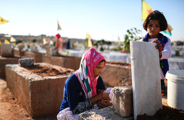 A woman whose husband was killed in the US-backed Kurdish and Arab forces’ battle of Raqqa, the main Syrian stronghold of the Daesh group, visits a cemetery in the Kurdish town of Kobani in northern Syria, on Sunday (AFP photo)