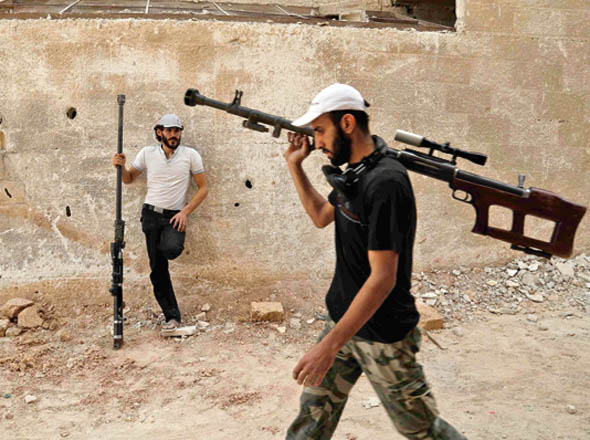 Syrian rebel fighters from the Faylaq Al Rahman brigade carry their homemade 12.7mm sniper rifle in Ain Tarma, in the eastern Ghouta area, a rebel stronghold east of the capital Damascus, on Tuesday (AFP photo)