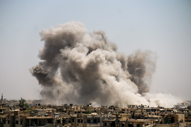 A huge explosion sends clouds into the air after government forces  reportedly carried out air and ground strikes over the rebel-held Ein Tarma district in the Eastern Ghouta region of Damascus, Syria, on Monday (Anadolu Agency photo)