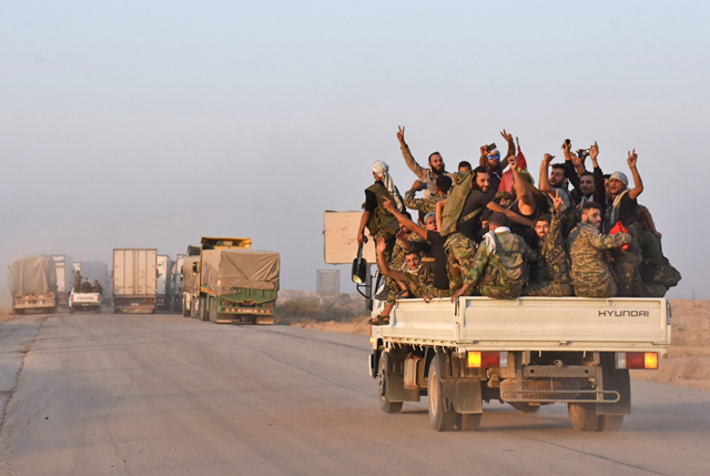 Syrian pro-government forces flash the sign of victory in the back of a vehicle on the outskirts of the eastern city of Deir Ezzor on Sunday, as they continue to press forward with Russian air cover in the offensive against Daesh militants across the province (AFP photo)