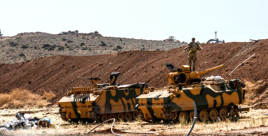 A Turkish soldier stands on an army armoured vehicle on Sunday at Syria-Turkey border at Reyhanli district in Hatay (AFP photo)