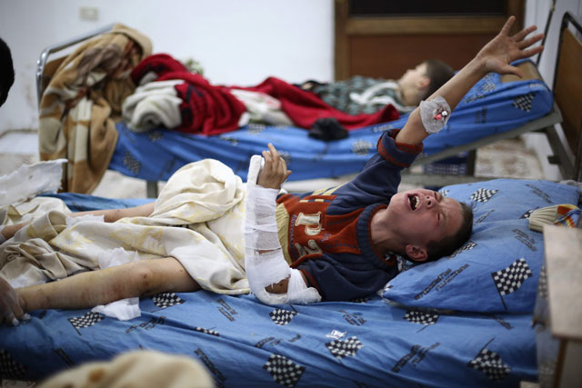 A Syrian boy who was injured in an air strike on a school in Jisreen screams as he receives treatment at a hospital in the rebel-held besieged town east of the capital Damascus on Sunday (AFP photo)