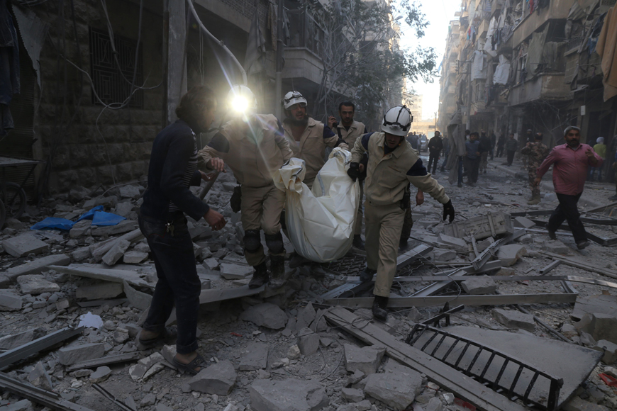 Syrian emergency personnel carry a body following an air strike on Tuesday in the rebel-held side of the northern city of Aleppo (AFP photo)