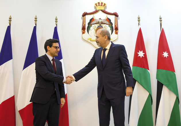 Deputy Prime Minister and Foreign Minister Ayman Safadi (right) shakes hand with French Minister of Foreign Affairs Stéphane Séjourné  ahead of a meeting in Amman on Sunday (Petra photo)