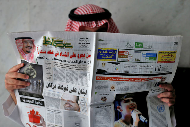 A man reads a newspaper in Riyadh, Saudi Arabia, on Sunday (Reuters photo)