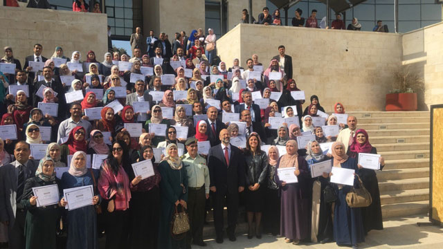 Education Minister Omar Razzaz poses for a group photo with teachers and principals who were awarded with appreciation certificates on Saturday (Photo by Sawsan Tabazah)