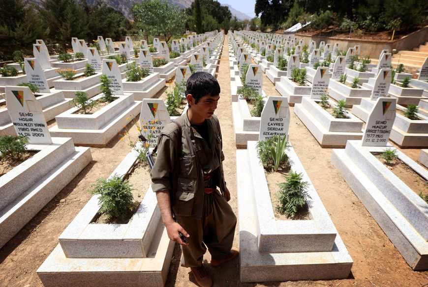 A member of the Kurdistan Workers’ Party (PKK) walks past graves at a cemetery in the Qandil mountain, the PKK headquarters in northern Iraq, on Wednesday (AFP photo)