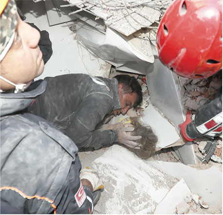 This handout photo released by the Turkish Disaster and Emergency Management Presidency (AFAD) shows a rescue worker comforting a 3-year-old girl, Ayda Gezgin, trapped in the rubble of a collapsed building after an earthquake in the Aegean port city of Izmir, on Tuesday (AFP photo)