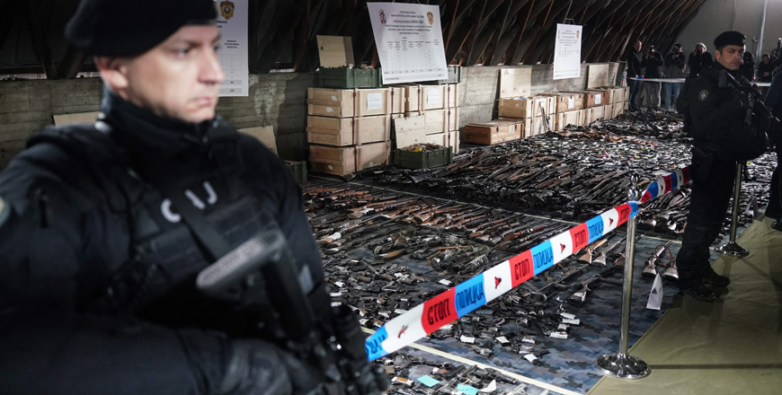 A Serbian police officer stands in front of weapons confiscated in the latest government disarmament action at a police depot near Smederevo, some 40km south of the capital Belgrade, on Sunday (AFP photo)
