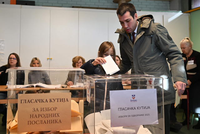 Dobrica Veselinovic, an opposition leader with the Serbia against Violence movement, with his daughter cast a ballot at a polling station, during parliamentary and local elections in Serbia, in Belgrade on Sunday (AFP photo)