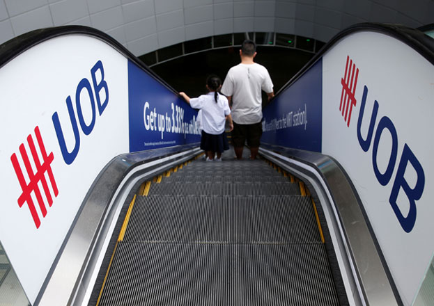 A man and his daughter passes United Overseas Bank signage at a mall in Singapore May 11, 2016 (Reuters photo)