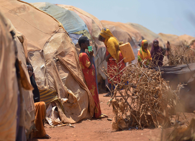 In this file photo taken on March 14, 2017, Internally displaced families stand next to their huts at a makeshift camp on the outskirts of Baidoa, in the south-western Bay region of Somalia, where thousands of people arrive daily after they fled the parched countryside (AFP photo)