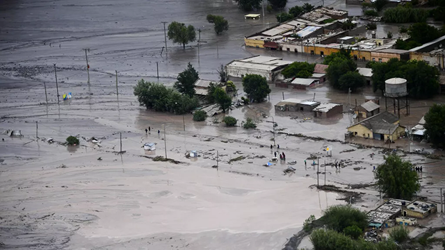 A flooded road is covered in mud after a landslide triggered by a storm in the village of Volcan (AFP photo)