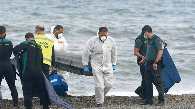Funeral workers carry the body of a migrant at the beach of the Spanish enclave of Ceuta, on May 20, 2021 (AFP photo)