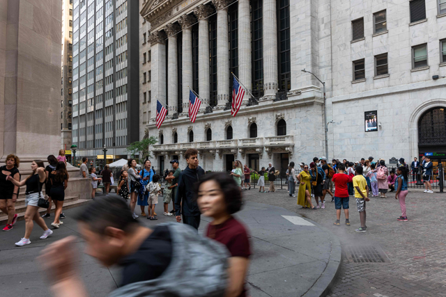 People walk through the financial district by the New York Stock Exchange (NYSE) on Wednesday, in New York City (AFP photo)