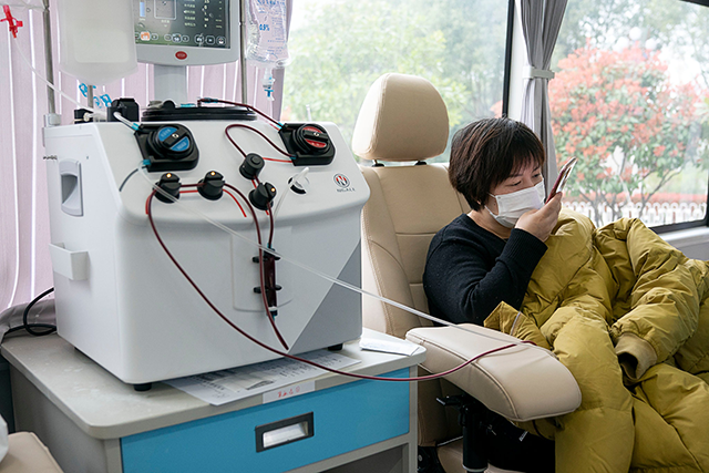 Zheng Yongheng, a recovered coronavirus patient, donating plasma at a mobile hospital in Wuhan earlier this month (AFP photo by Xiong Qi)