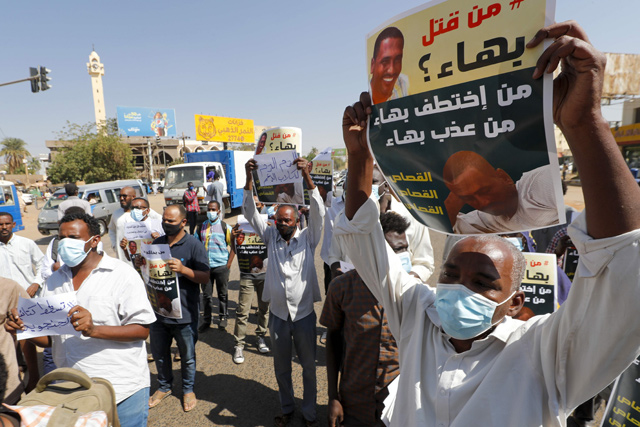Sudanese mourners carry placards asking who killed Bahaa Eddine Nouri, a 45-year-old pro-democracy activist who was allegedly tortured and killed by members of the powerful Rapid Support Forces paramilitary, during his funeral procession in Kalakla, a district in southern Khartoum, on Tuesday (AFP photo)